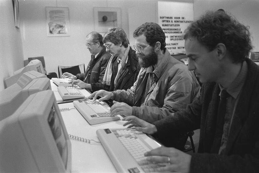 Vier mannen op een rij achter een toetsenbord tijdens de Personal Computerbeurs in de RAI